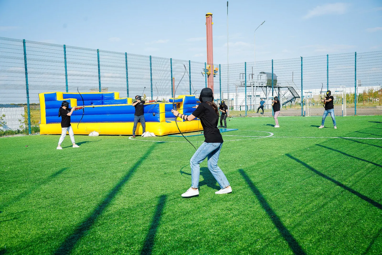Участник корпоративной игры Archery Tag с луком на площадке